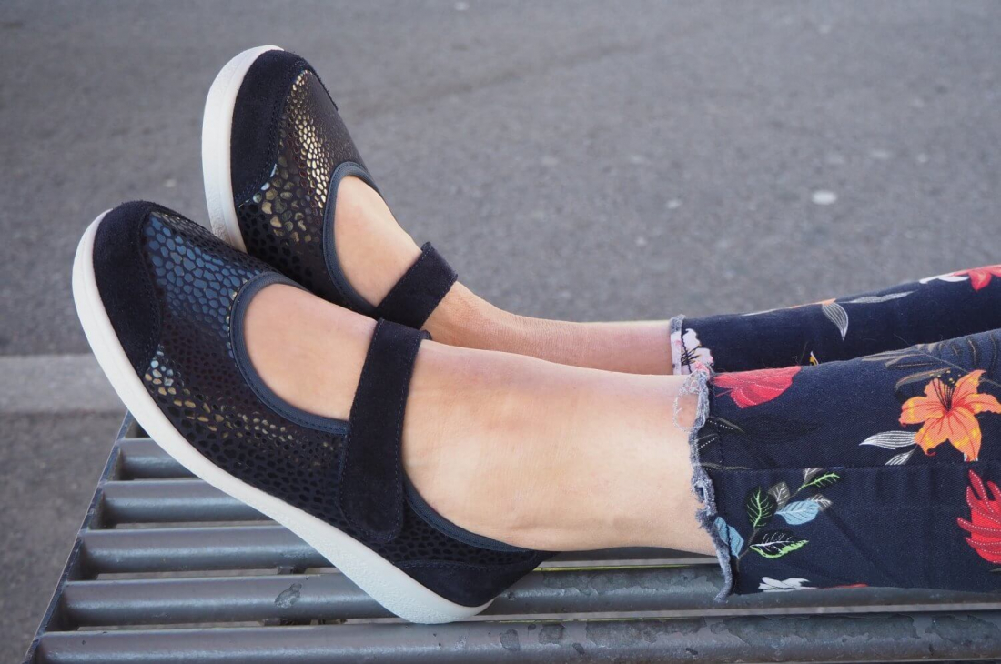 Varomed Sevilla Ballerina Weite K: Damen-Ballerina in der Farbe Marine, getragen von einer Dame. Extraweite Passform mit weichem Stretchmaterial, Klettverschluss und herausnehmbarer Einlegesohle – ideal für empfindliche Füße. Artikelnummer 77701.